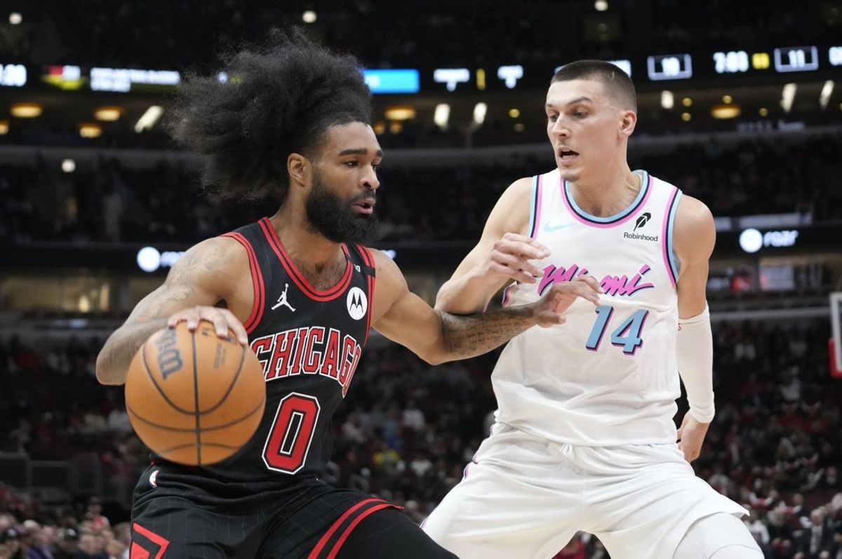 Apr 9, 2025; Chicago, Illinois, USA; Miami Heat forward Andrew Wiggins (22) defends Chicago Bulls guard Coby White (0) during the first quarter at United Center. Mandatory Credit: David Banks-Imagn Images