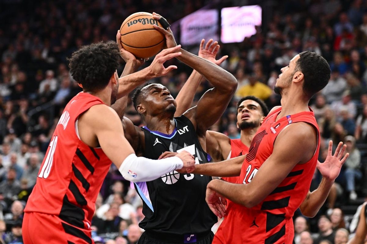 Apr 9, 2025; Salt Lake City, Utah, USA;  Utah Jazz forward Oscar Tshiebwe (34) battles to shoot the ball while being defended by Portland Trail Blazers forward Justin Minaya (10) and forward Kris Murray (24) in the first half at Delta Center. Mandatory Credit: Jamie Sabau-Imagn Images