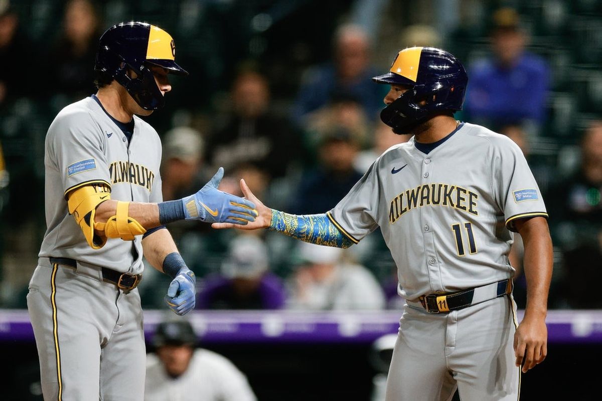 Apr 9, 2025; Denver, Colorado, USA; Milwaukee Brewers designated hitter Christian Yelich (22) celebrates his two run home run with left fielder Jackson Chourio (11) in the ninth inning against the Colorado Rockies at Coors Field. Mandatory Credit: Isaiah J. Downing-Imagn Images