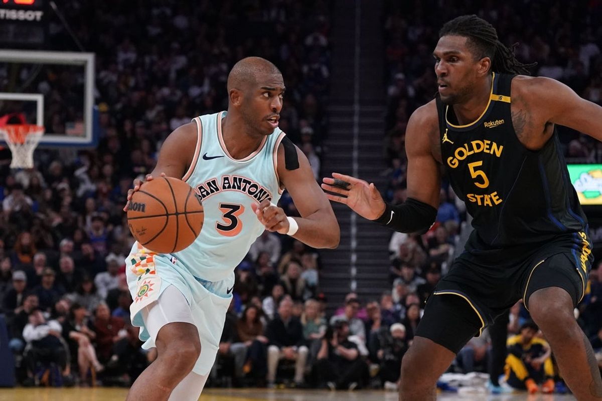Apr 9, 2025; San Francisco, California, USA;  San Antonio Spurs guard Chris Paul (3) dribbles against Golden State Warriors forward Kevon Looney (5) in the fourth quarter at Chase Center. Mandatory Credit: David Gonzales-Imagn Images