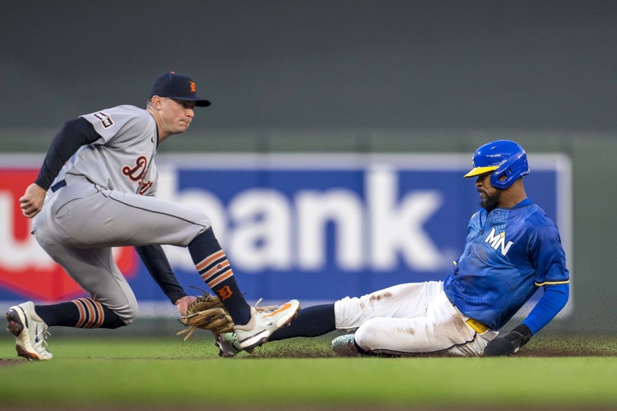 Apr 11, 2025; Minneapolis, Minnesota, USA; Minnesota Twins center fielder Byron Buxton (25) steals second base by sliding before Detroit Tigers shortstop Trey Sweeney (27) can make a tag in the second inning at Target Field. Mandatory Credit: Jesse Johnson-Imagn Images