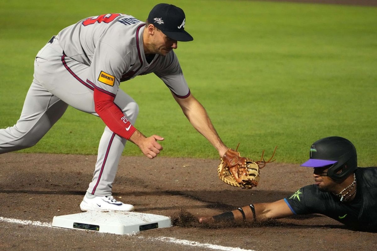 Apr 11, 2025; Tampa, Florida, USA; Tampa Bay Rays third base Christopher Morel (24) dives back to first as Atlanta Braves first base Matt Olson (28) tries to make the tag during the first inning at George M. Steinbrenner Field. Mandatory Credit: Dave Nelson-Imagn Images