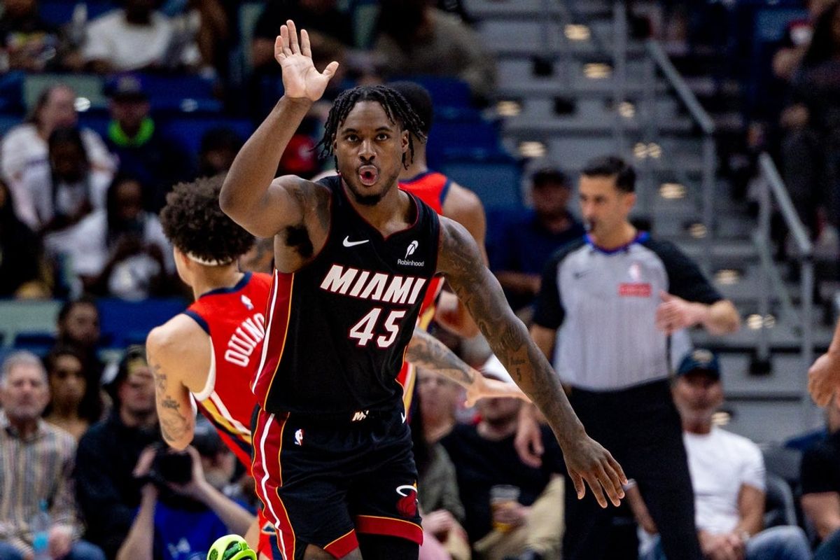 Apr 11, 2025; New Orleans, Louisiana, USA; Miami Heat guard Davion Mitchell (45) reacts taking a basket against New Orleans Pelicans guard Lester Quinones (22) during the second half at Smoothie King Center. Mandatory Credit: Stephen Lew-Imagn Images