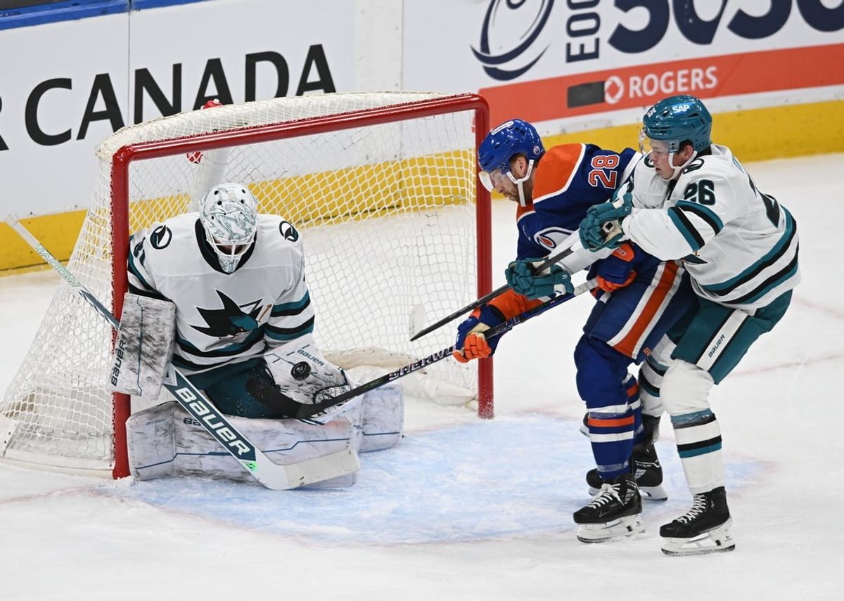Apr 11, 2025; Edmonton, Alberta, CAN; San Jose Sharks goalie Georgi Romanov (31) stops a shot from Edmonton Oilers right winger Connor Brown (28) with Sharks defenceman Jack Thompson (26) skating in during the second period at Rogers Place. Mandatory Credit: Walter Tychnowicz-Imagn Images