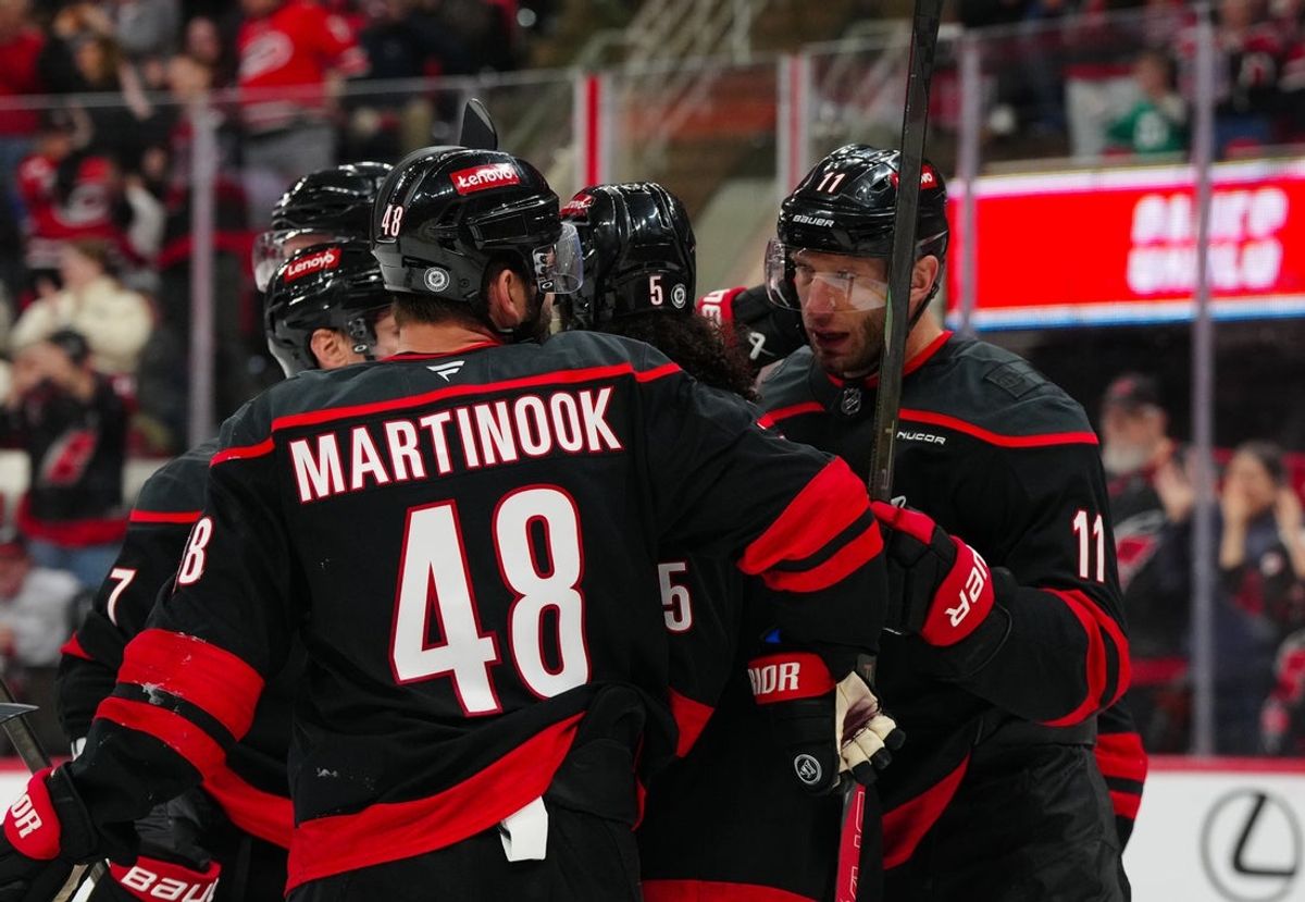 Apr 12, 2025; Raleigh, North Carolina, USA;  Carolina Hurricanes center Jordan Staal (11) is congratulated by left wing Jordan Martinook (48) and defenseman Jalen Chatfield (5) after his goal against the New York Rangers during the third period at Lenovo Center. Mandatory Credit: James Guillory-Imagn Images