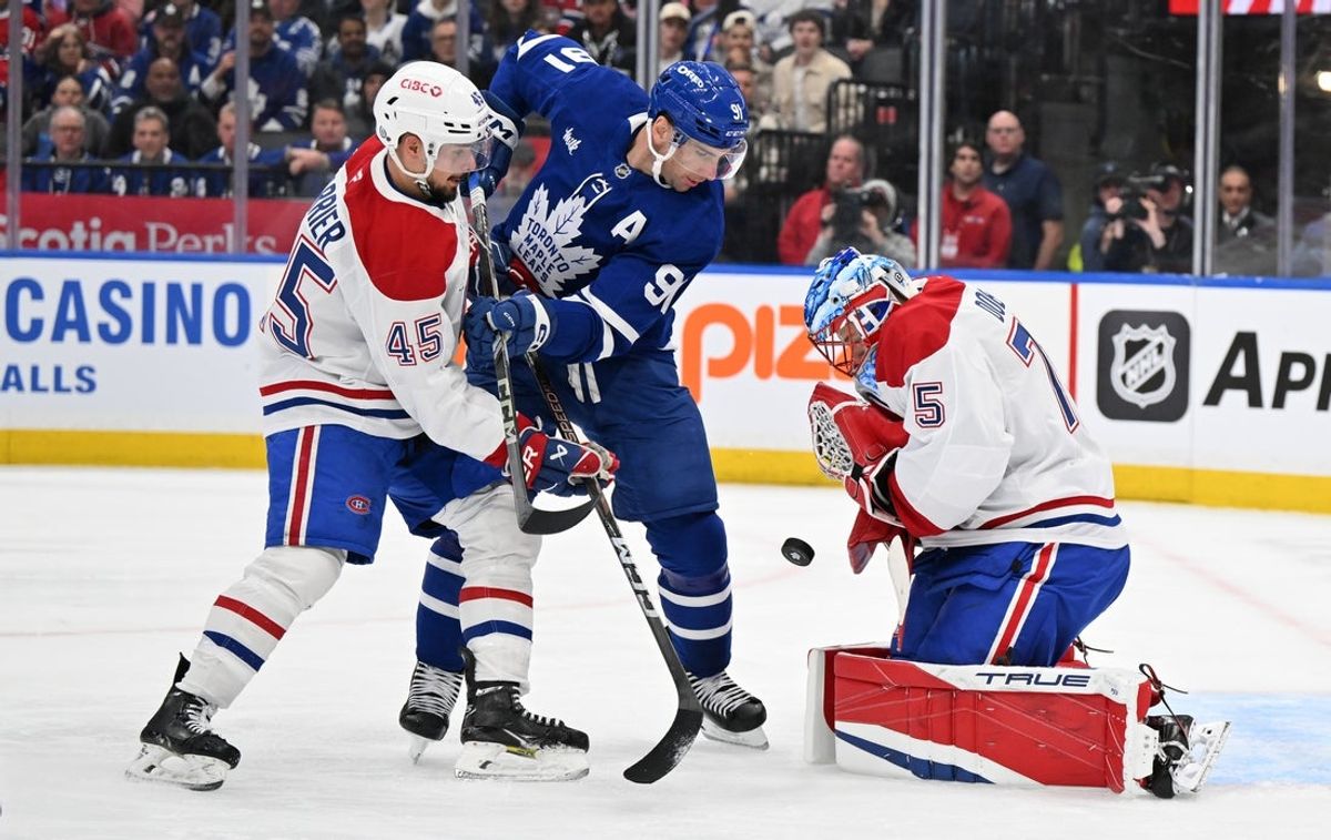 Apr 12, 2025; Toronto, Ontario, CAN;  Montreal Canadiens goalie Jakub Dobes (75) makes a save as defenseman Alexandre Carrier (45) covers Toronto Maple Leafs forward John Tavares (91) in the first period at Scotiabank Arena. Mandatory Credit: Dan Hamilton-Imagn Images