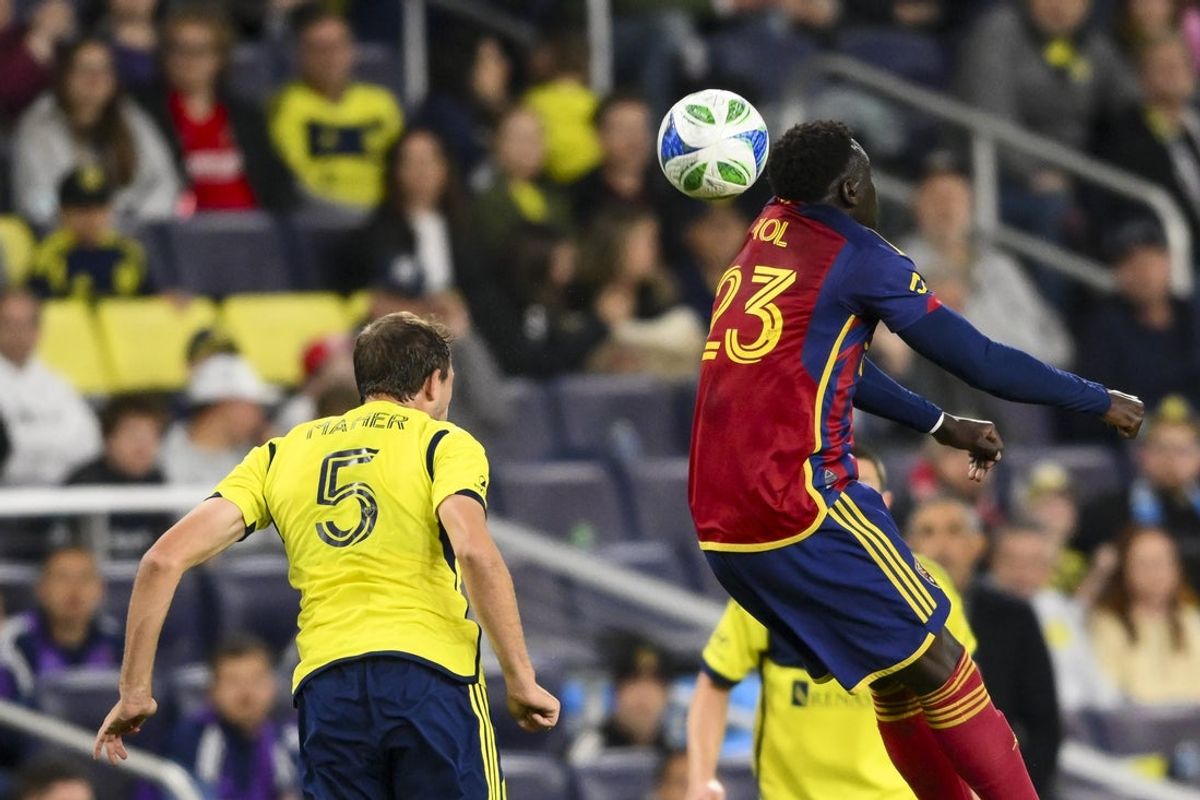 Apr 12, 2025; Nashville, Tennessee, USA;  Nashville SC defender Jack Maher (5) heads the ball into Real Salt Lake forward Ariath Piol (23) during the first half at Geodis Park. Mandatory Credit: Steve Roberts-Imagn Images