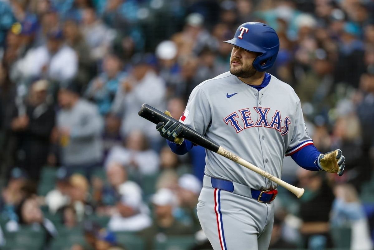 Apr 12, 2025; Seattle, Washington, USA; Texas Rangers first baseman Jake Burger (21) reacts following a strikeout against the Seattle Mariners to end the top of the first inning at T-Mobile Park. Mandatory Credit: Joe Nicholson-Imagn Images