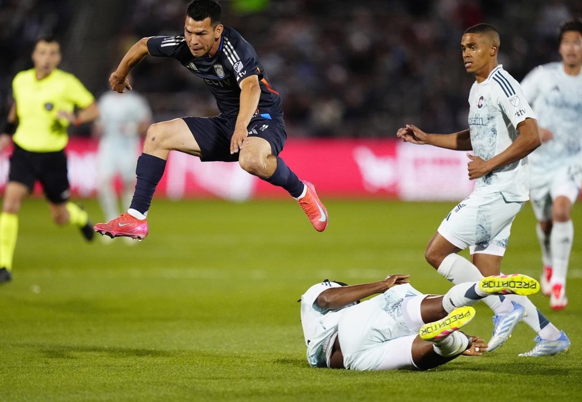 Apr 12, 2025; Commerce City, Colorado, USA; San Diego FC midfielder Chucky Lozano (11) leaps over Colorado Rapids defender Chidozie Awaziem (6) in the first half at Dick's Sporting Goods Park. Mandatory Credit: Ron Chenoy-Imagn Images