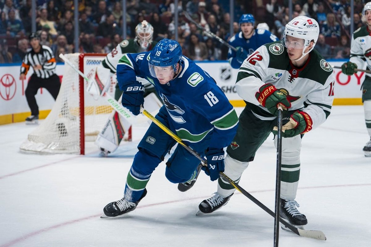 Apr 12, 2025; Vancouver, British Columbia, CAN; Minnesota Wild forward Matt Boldy (12) battles with Vancouver Canucks forward Drew O'Connor (18) in the second period at Rogers Arena. Mandatory Credit: Bob Frid-Imagn Images
