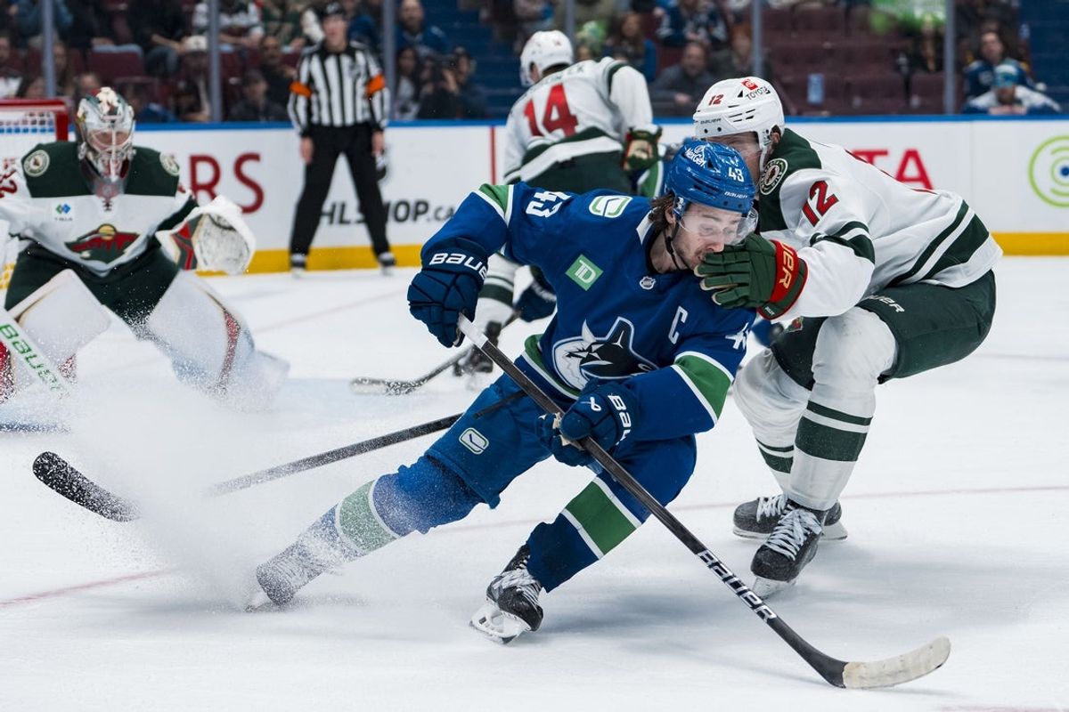 Apr 12, 2025; Vancouver, British Columbia, CAN; Minnesota Wild forward Matt Boldy (12) checks Vancouver Canucks defenseman Quinn Hughes (43) in overtime at Rogers Arena. Mandatory Credit: Bob Frid-Imagn Images