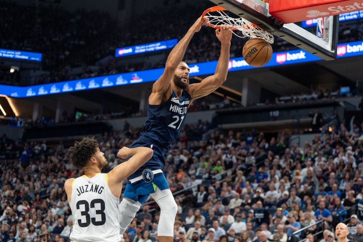 Apr 13, 2025; Minneapolis, Minnesota, USA; Minnesota Timberwolves center Rudy Gobert (27) dunks over Utah Jazz guard Johnny Juzang (33) in the second quarter at Target Center. Mandatory Credit: Matt Blewett-Imagn Images
