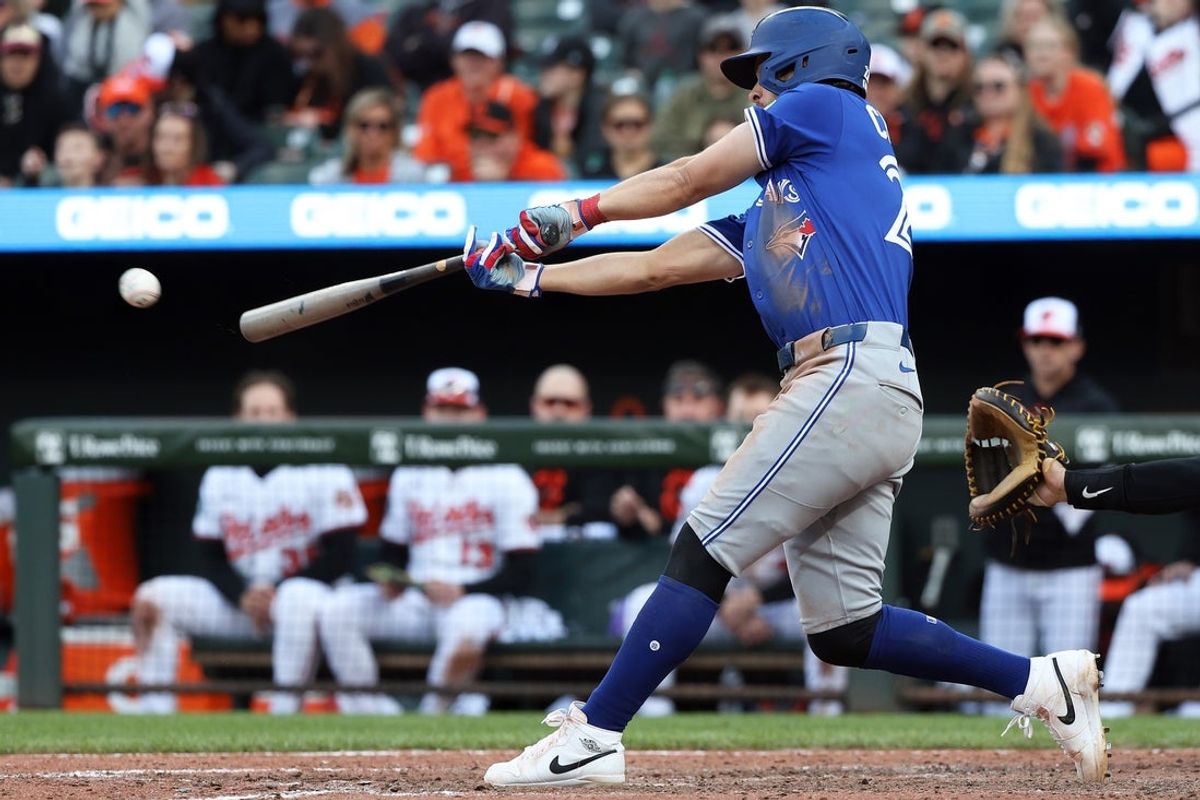 Apr 13, 2025; Baltimore, Maryland, USA; Toronto Blue Jays third baseman Ernie Clement (22) hits a single during the tenth inning against the Baltimore Orioles at Oriole Park at Camden Yards. Mandatory Credit: Daniel Kucin Jr.-Imagn Images