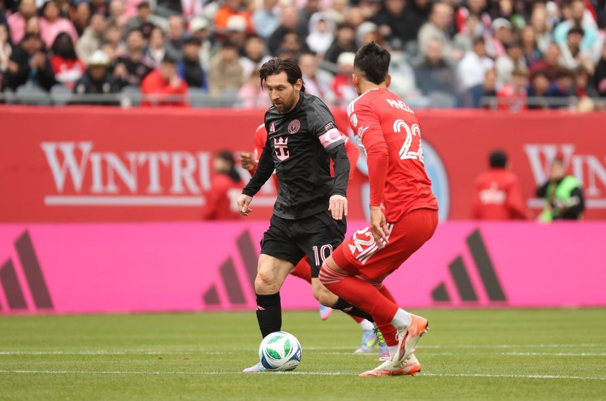 Apr 13, 2025; Chicago, Illinois, USA; Inter Miami CF forward Lionel Messi (10) and Chicago Fire FC defender Mauricio Pineda (22) battle for control of the ball during the first half at Soldier Field. Mandatory Credit: Talia Sprague-Imagn Images