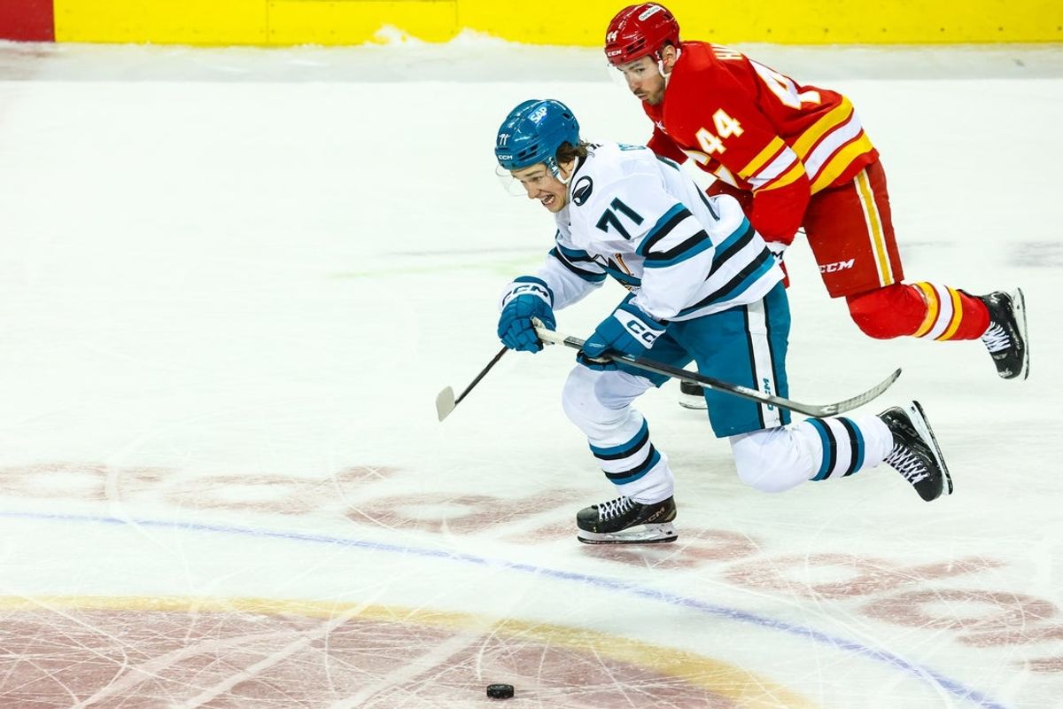 Apr 13, 2025; Calgary, Alberta, CAN; San Jose Sharks center Macklin Celebrini (71) and Calgary Flames defenseman Joel Hanley (44) battles for the puck during the second period at Scotiabank Saddledome. Mandatory Credit: Sergei Belski-Imagn Images