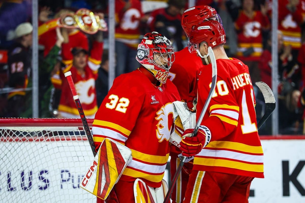 Apr 13, 2025; Calgary, Alberta, CAN; Calgary Flames goaltender Dustin Wolf (32) celebrate win with teammates after defeating the San Jose Sharks at Scotiabank Saddledome. Mandatory Credit: Sergei Belski-Imagn Images