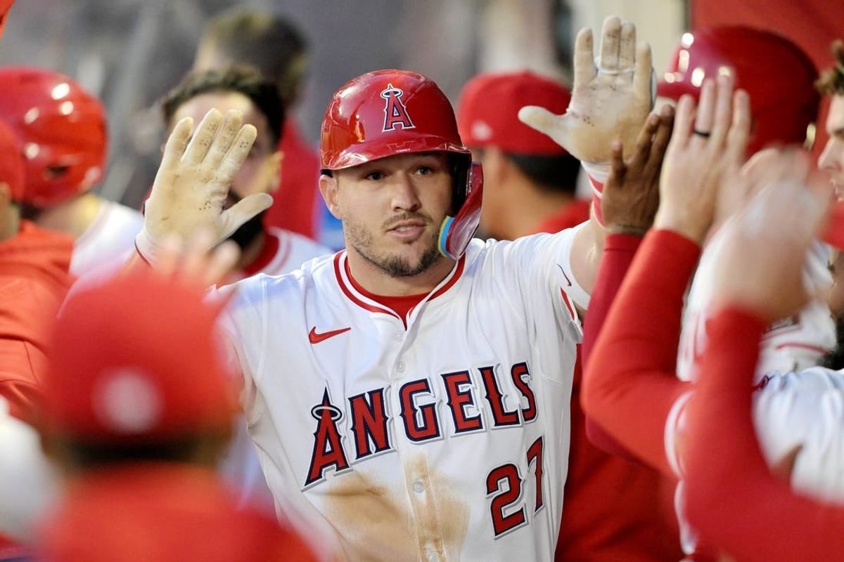 Apr 8, 2024; Anaheim, California, USA; Los Angeles Angels outfielder Mike Trout (27) celebrates with teammates in the dugout after hitting a solo home run in the third inning against the Tampa Bay Rays at Angel Stadium.