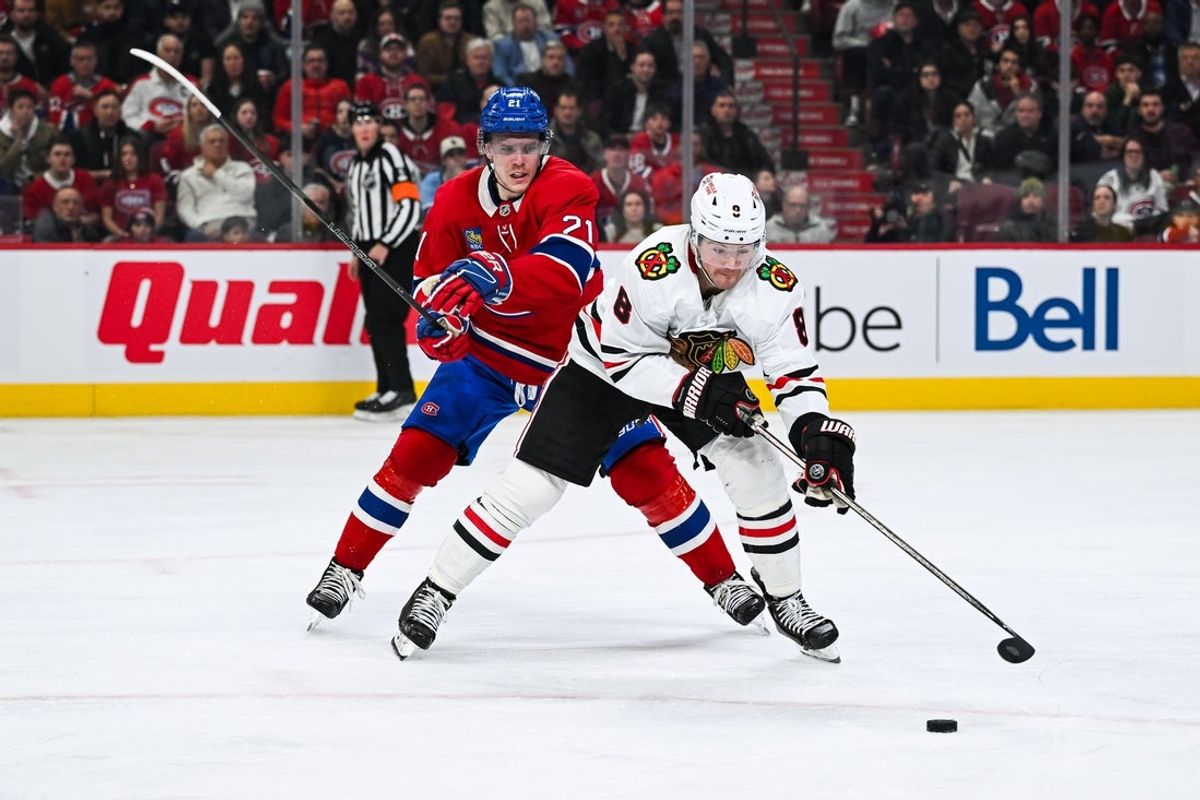 Apr 14, 2025; Montreal, Quebec, CAN; Chicago Blackhawks center Ryan Donato (8) plays the puck against Montreal Canadiens defenseman Kaiden Guhle (21) in the third period at Bell Centre. Mandatory Credit: David Kirouac-Imagn Images