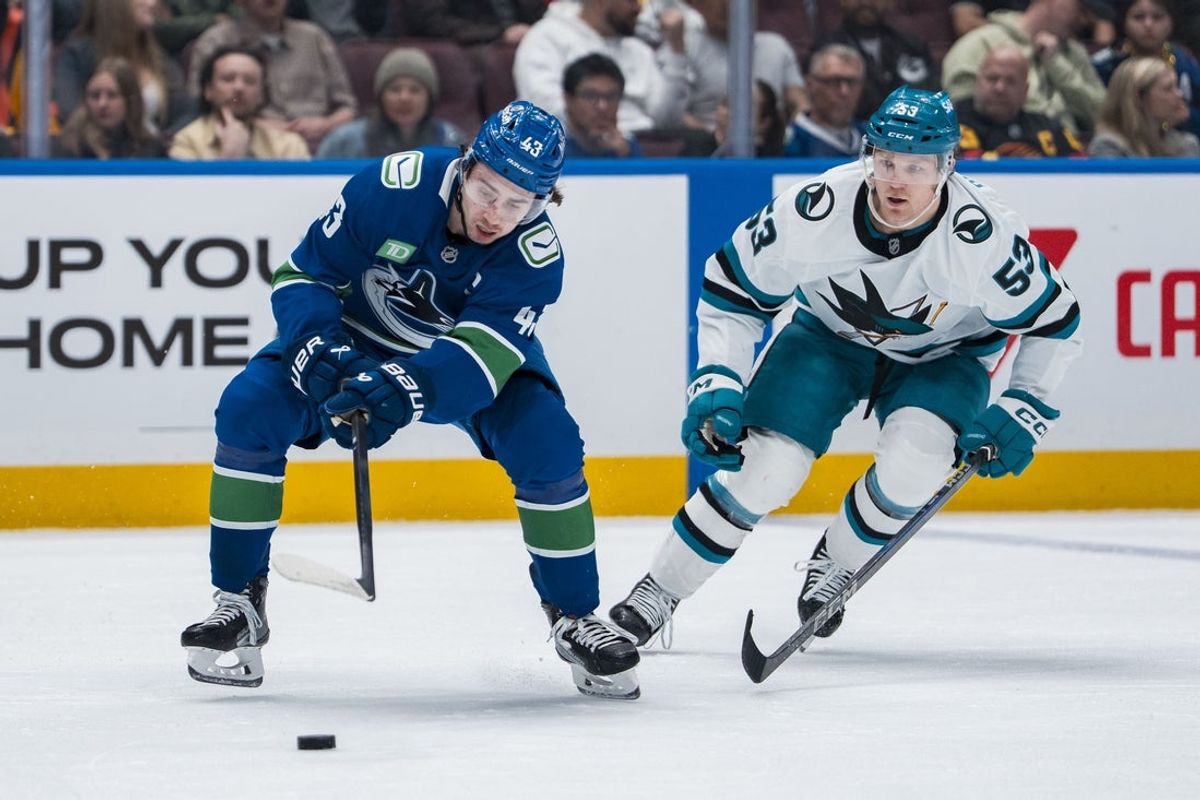 Apr 14, 2025; Vancouver, British Columbia, CAN; San Jose Sharks forward Ty Dellandrea (53) defends against Vancouver Canucks defenseman Quinn Hughes (43) in the first period at Rogers Arena. Mandatory Credit: Bob Frid-Imagn Images