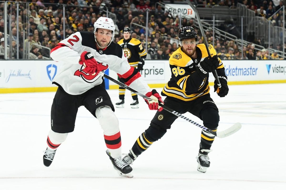 Apr 15, 2025; Boston, Massachusetts, USA; New Jersey Devils defenseman Brian Dumoulin (2) and Boston Bruins right wing David Pastrnak (88) skates after the puck during the first period at TD Garden. Mandatory Credit: Bob DeChiara-Imagn Images