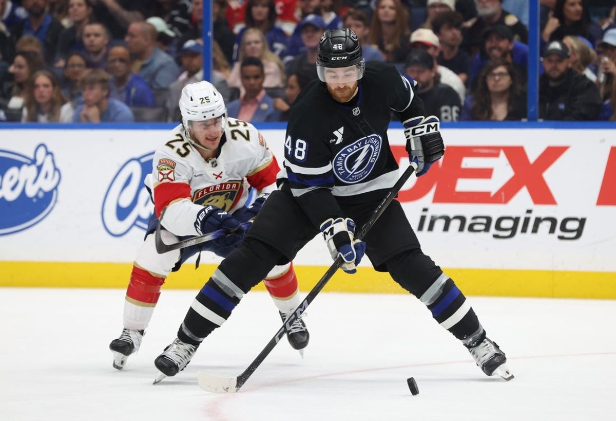 Apr 15, 2025; Tampa, Florida, USA; Tampa Bay Lightning defenseman Nick Perbix (48) skates with the puck as Florida Panthers right wing Mackie Samoskevich (25) defends during the first period at Amalie Arena. Mandatory Credit: Kim Klement Neitzel-Imagn Images