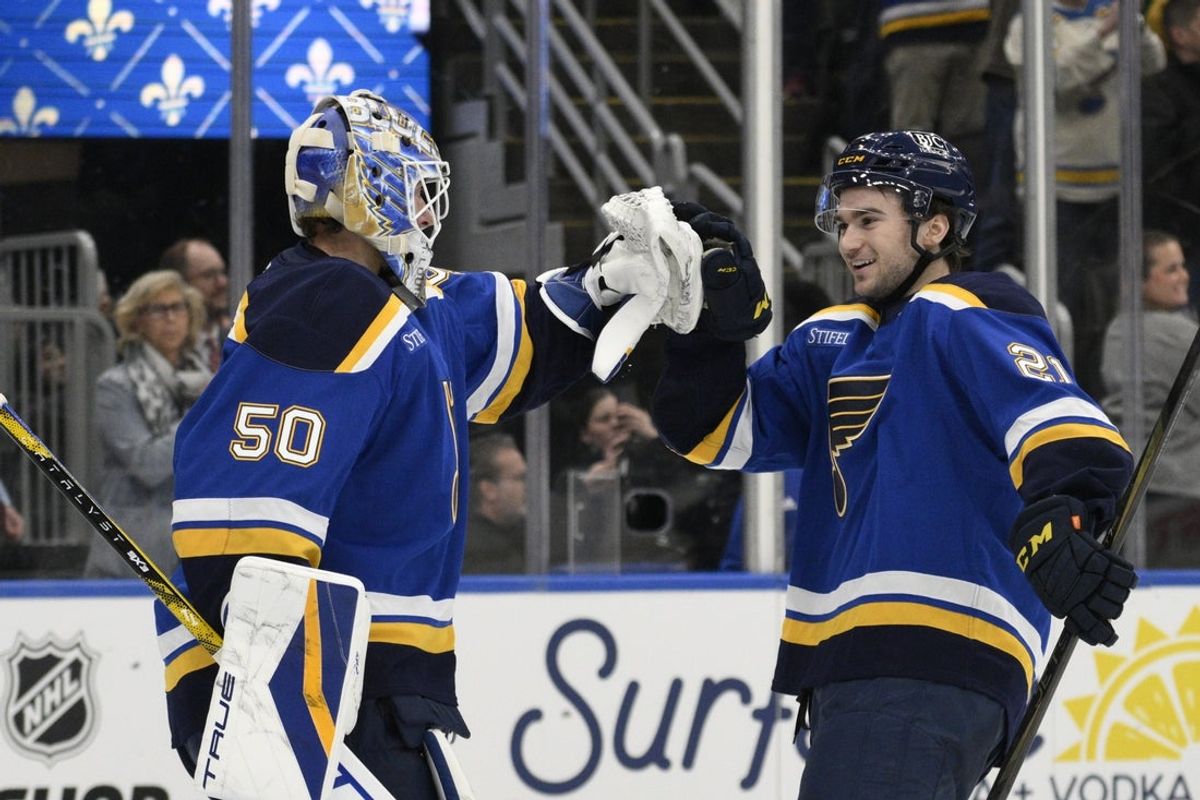 Apr 15, 2025; St. Louis, Missouri, USA; St. Louis Blues right wing Jimmy Snuggerud (21) and goaltender Jordan Binnington (50) celebrate a win against the Utah Hockey Club at Enterprise Center to clinch a spot in the playoffs. Mandatory Credit: Jeff Le-Imagn Images