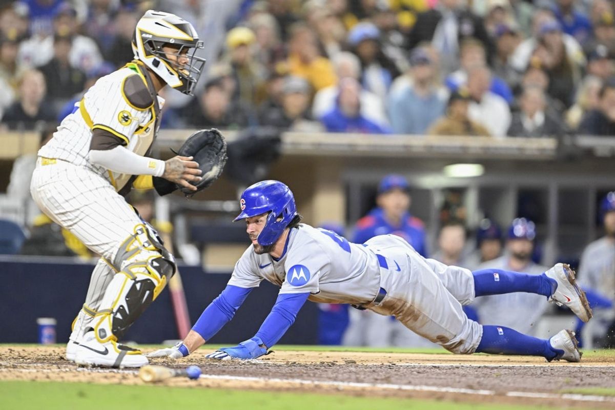 Apr 15, 2025; San Diego, California, USA; Chicago Cubs shortstop Dansby Swanson (7) slides as he scores ahead of the throw to San Diego Padres catcher Martin Maldonado (15) during the sixth inning at Petco Park. Mandatory Credit: Denis Poroy-Imagn Images
