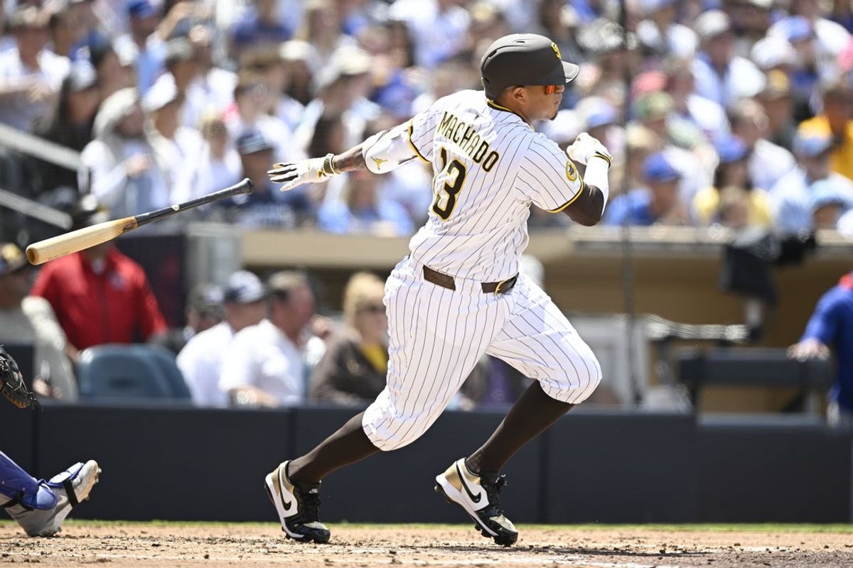 Apr 16, 2025; San Diego, California, USA; San Diego Padres third baseman Manny Machado (13) hits an RBI single during the third inning against the Chicago Cubs at Petco Park. Mandatory Credit: Denis Poroy-Imagn Images