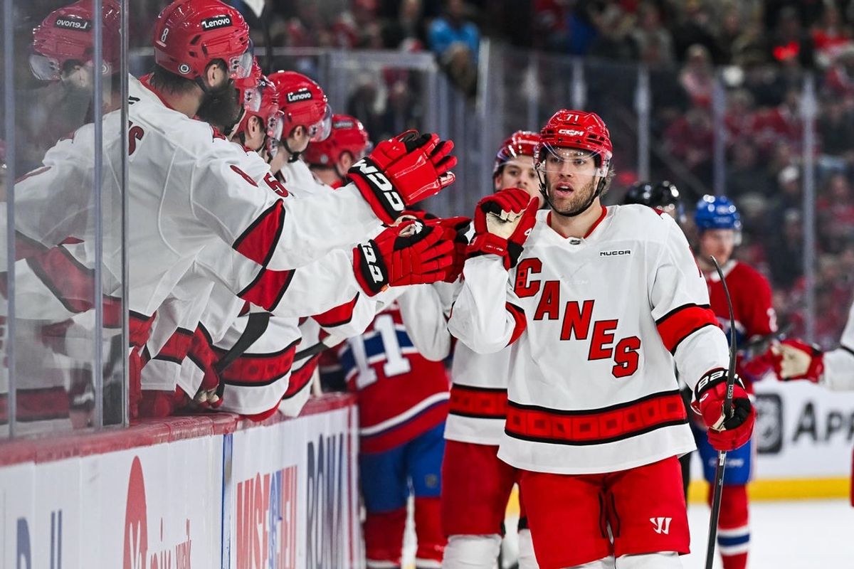 Apr 16, 2025; Montreal, Quebec, CAN; Carolina Hurricanes left wing Taylor Hall (71) celebrates with his teammates at the bench his goal against the Montreal Canadiens in the first period at Bell Centre. Mandatory Credit: David Kirouac-Imagn Images