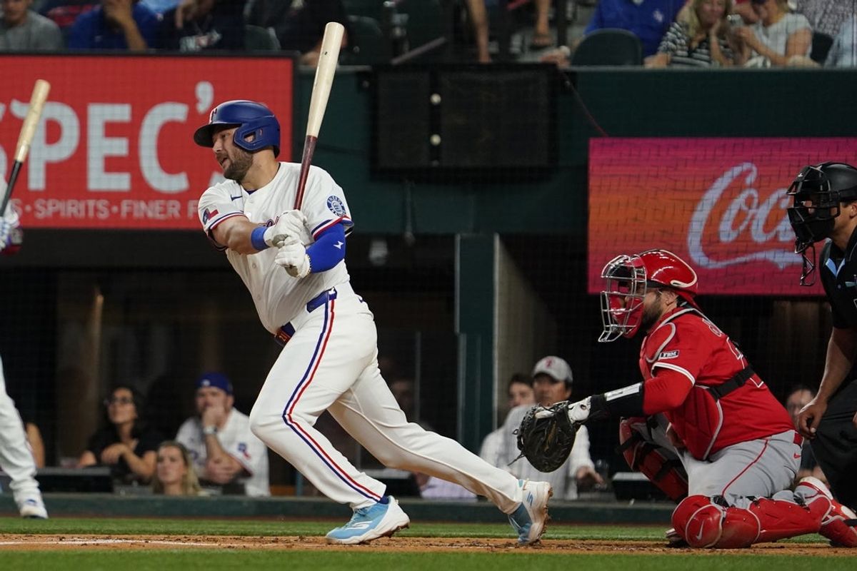 Apr 16, 2025; Arlington, Texas, USA; Texas Rangers third baseman Jake Burger (21) hits an RBI single during the second inning against the Los Angeles Angels at Globe Life Field. Mandatory Credit: Raymond Carlin III-Imagn Images