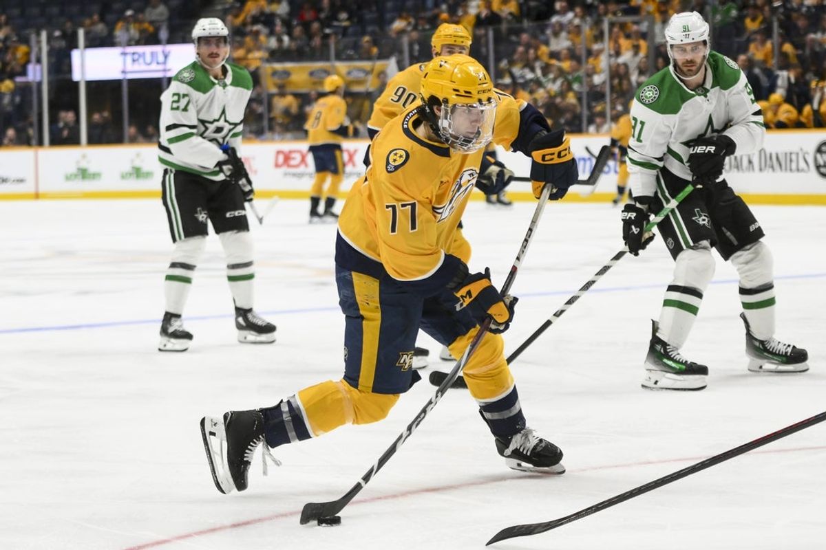 Apr 16, 2025; Nashville, Tennessee, USA;  Nashville Predators right wing Luke Evangelista (77) takes a shot on goal against the Dallas Stars during the third period at Bridgestone Arena. Mandatory Credit: Steve Roberts-Imagn Images
