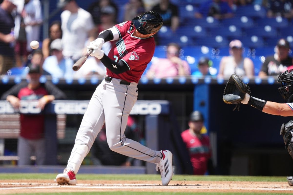 Apr 17, 2025; Miami, Florida, USA;  Arizona Diamondbacks first baseman Pavin Smith (26) hits a home run in the bottom of the first inning against the Miami Marlins at loanDepot Park. Mandatory Credit: Jim Rassol-Imagn Images