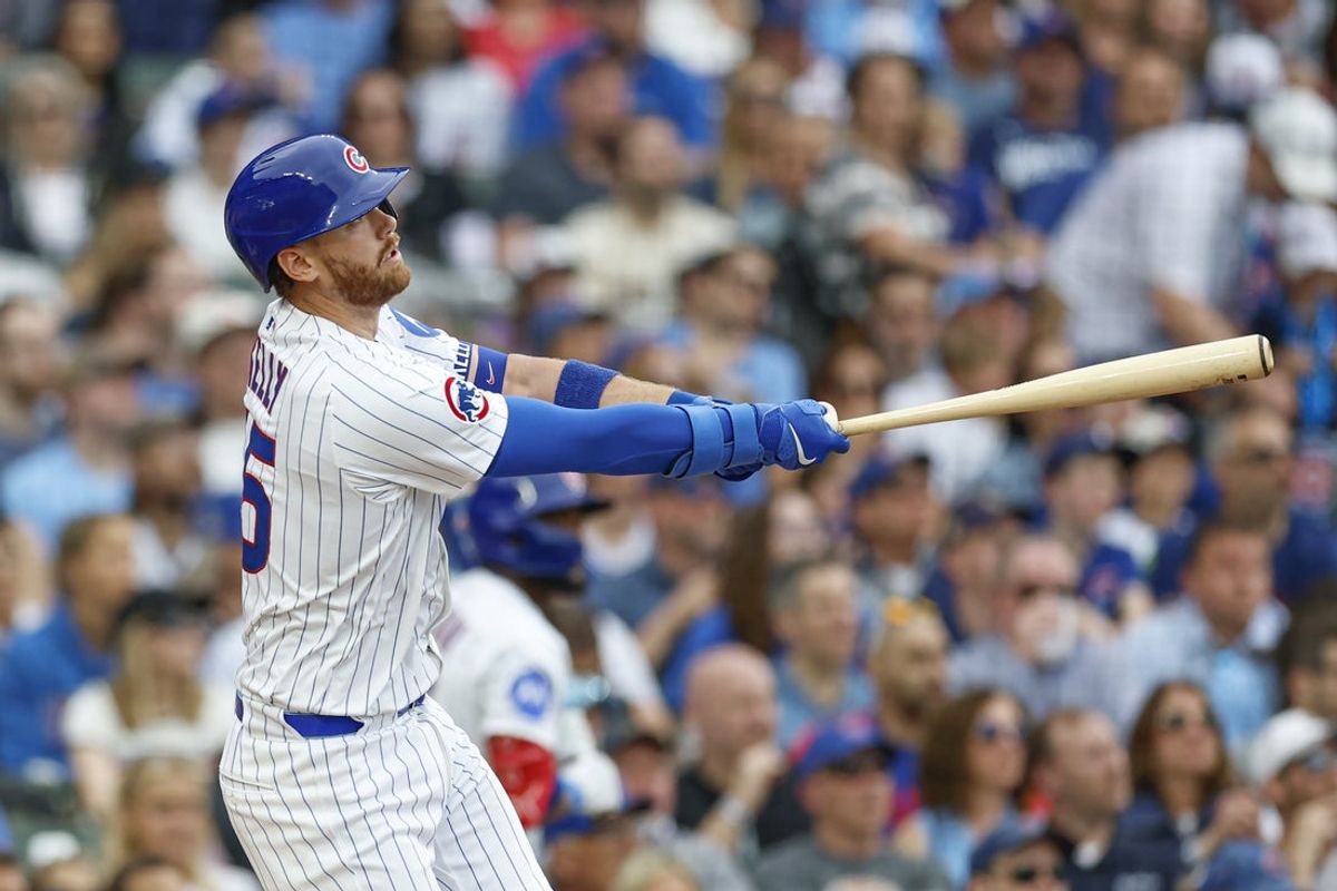 Apr 18, 2025; Chicago, Illinois, USA; Chicago Cubs catcher Carson Kelly (15) hits a two-run home run against the Arizona Diamondbacks during the second inning at Wrigley Field. Mandatory Credit: Kamil Krzaczynski-Imagn Images