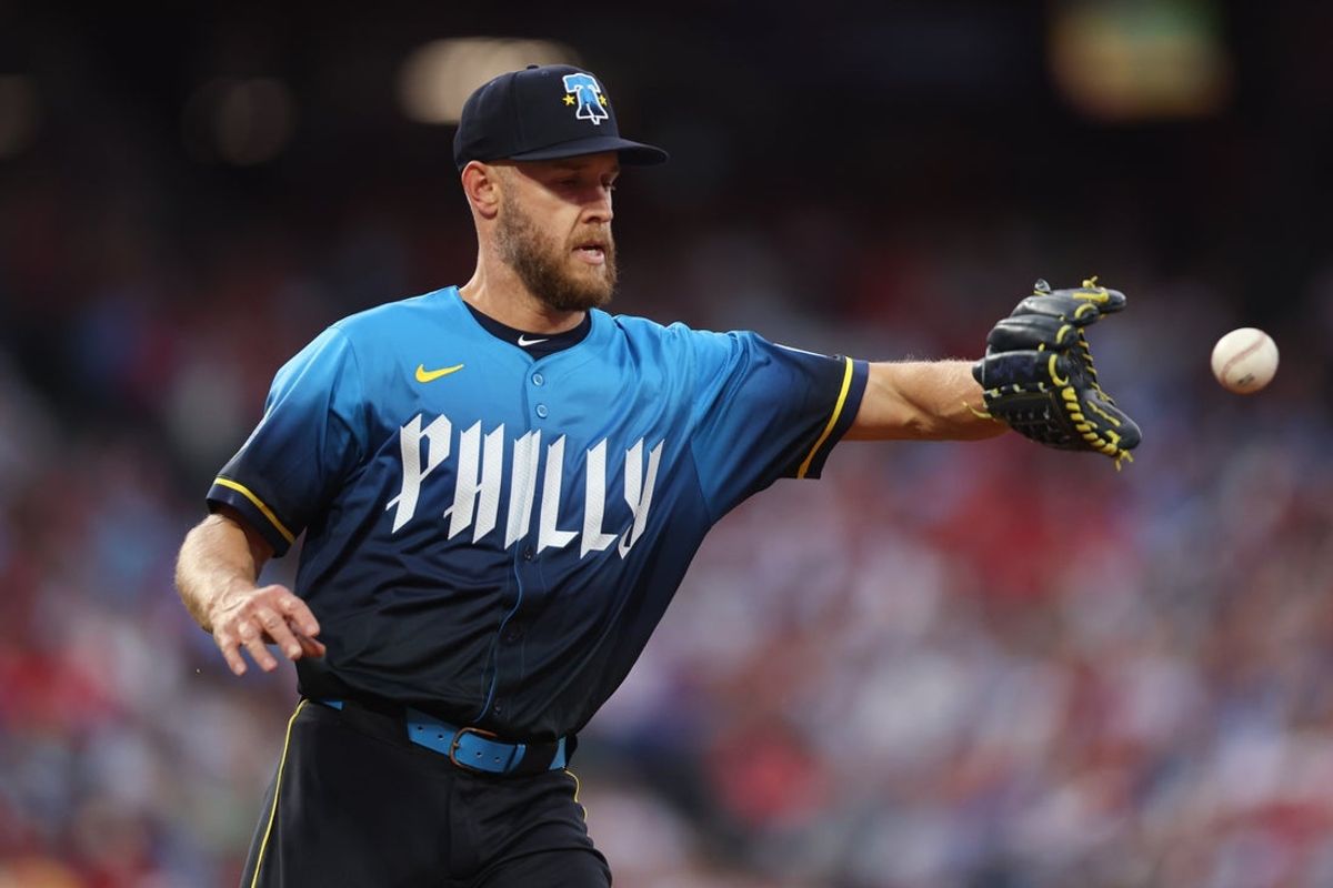 Apr 18, 2025; Philadelphia, Pennsylvania, USA; Philadelphia Phillies pitcher Zack Wheeler (45) catches a ball for an out while covering first base on a play against the Miami Marlins during the third inning at Citizens Bank Park. Mandatory Credit: Bill Streicher-Imagn Images