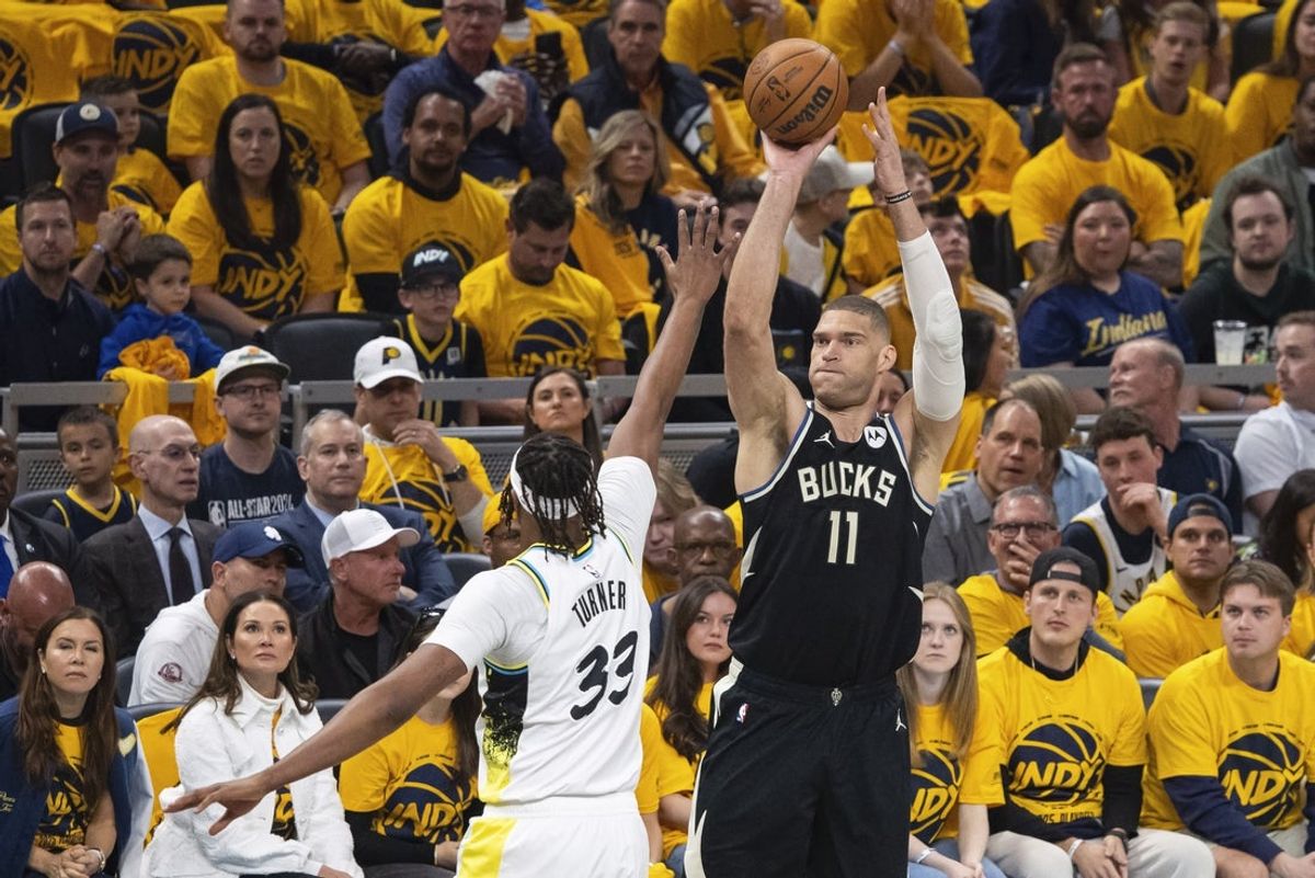 Apr 19, 2025; Indianapolis, Indiana, USA;  Milwaukee Bucks center Brook Lopez (11) shoots the ball while  Indiana Pacers center Myles Turner (33) defends in the first half at Gainbridge Fieldhouse. Mandatory Credit: Trevor Ruszkowski-Imagn Images