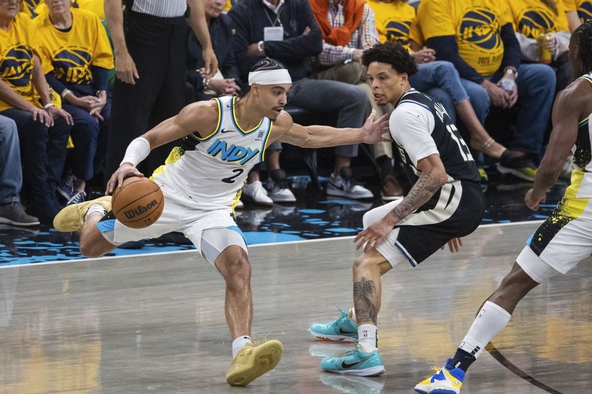 Apr 19, 2025; Indianapolis, Indiana, USA;  Indiana Pacers guard Andrew Nembhard (2) dribbles the ball while Milwaukee Bucks guard Ryan Rollins (13) defends in the first half at Gainbridge Fieldhouse. Mandatory Credit: Trevor Ruszkowski-Imagn Images