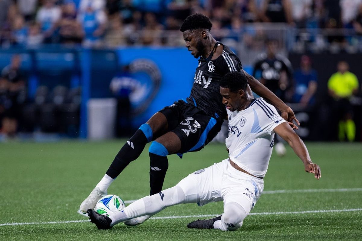 Apr 19, 2025; Charlotte, North Carolina, USA; Charlotte FC forward Patrick Agyemang (33) is pulled down by San Diego FC defender Andrés Reyes (4) in the penalty box during the first half at Bank of America Stadium. Mandatory Credit: Scott Kinser-Imagn Images