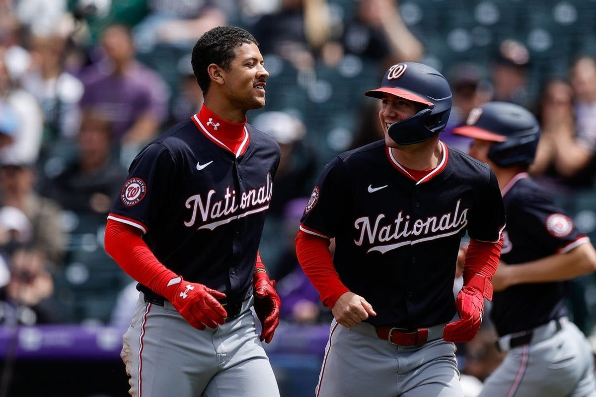 Apr 20, 2025; Denver, Colorado, USA; Washington Nationals third baseman Trey Lipscomb (38) and center fielder Jacob Young (30) react after scoring on a throwing error in the second inning against the Colorado Rockies at Coors Field. Mandatory Credit: Isaiah J. Downing-Imagn Images