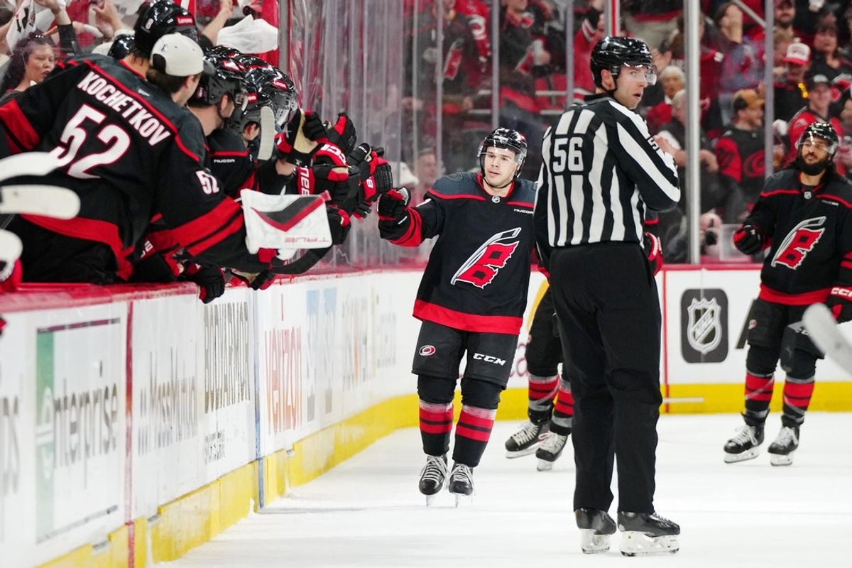 Apr 20, 2025; Raleigh, North Carolina, USA; Carolina Hurricanes center Logan Stankoven (22) celebrates with the bench after scoring a goal against the New Jersey Devils during the second period of game one of the first round of the 2025 Stanley Cup Playoffs at Lenovo Center. Mandatory Credit: James Guillory-Imagn Images