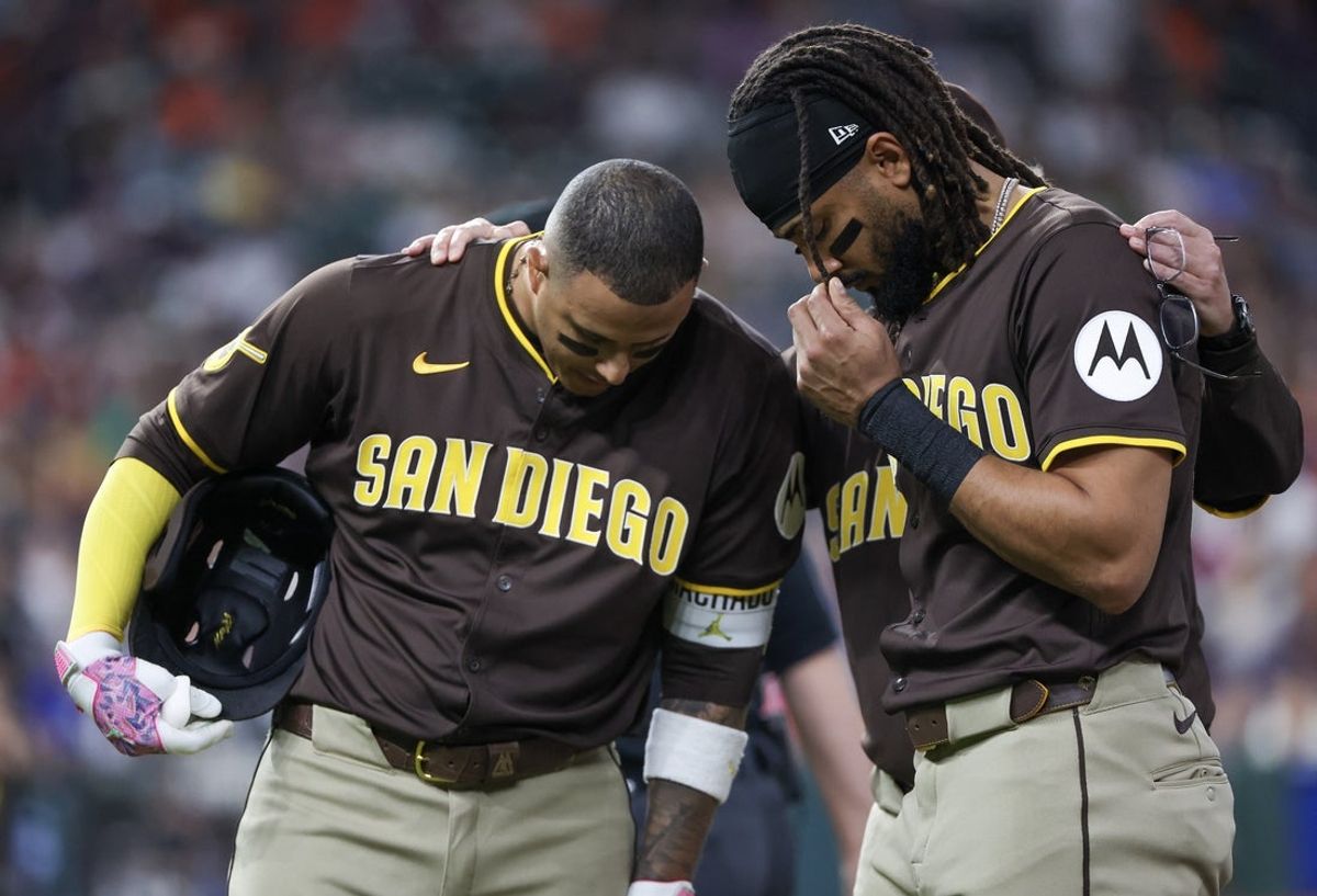Apr 20, 2025; Houston, Texas, USA;San Diego Padres third baseman Manny Machado (13) and  right fielder Fernando Tatis Jr. (23) pray for San Diego Padres designated hitter Luis Arraez (4)  after he colliding with Houston Astros first baseman Christian Walker (8) (not pictured )on the first base line in the first inning at Daikin Park.Arraez  was carted off the field . Mandatory Credit: Thomas Shea-Imagn Images