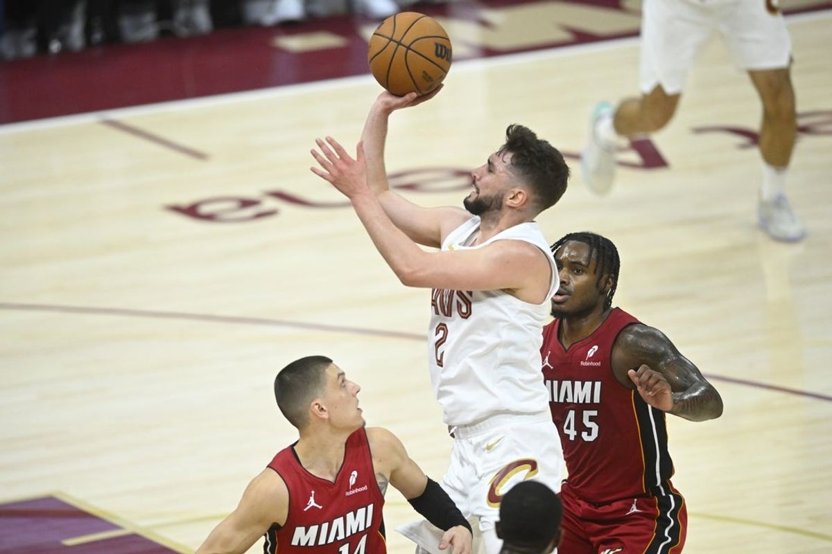 Apr 20, 2025; Cleveland, Ohio, USA; Cleveland Cavaliers guard Ty Jerome (2) shoots between Miami Heat guard Tyler Herro (14) and guard Davion Mitchell (45) in the fourth quarter at Rocket Arena. Mandatory Credit: David Richard-Imagn Images
