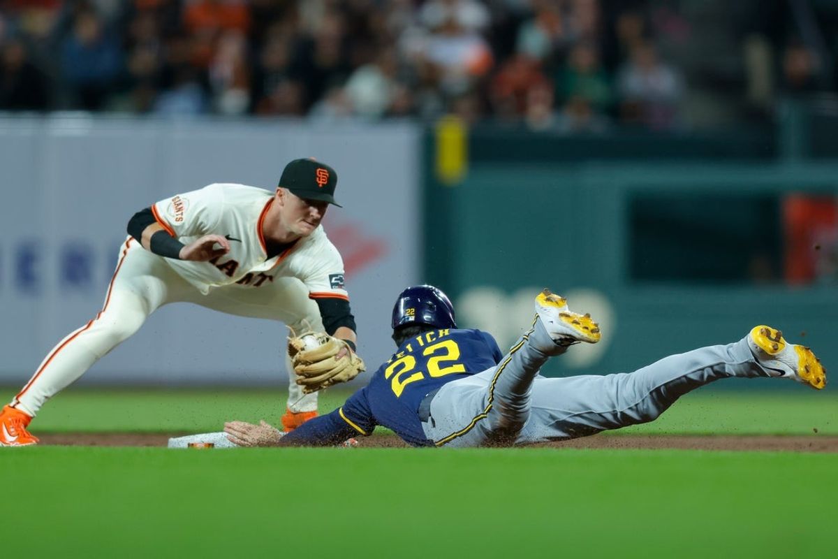 Apr 21, 2025; San Francisco, California, USA; Milwaukee Brewers designated hitter Christian Yelich (22) avoids the tag by San Francisco Giants second baseman Tyler Fitzgerald (49) to steal second base during the fifth inning at Oracle Park. Mandatory Credit: Sergio Estrada-Imagn Images