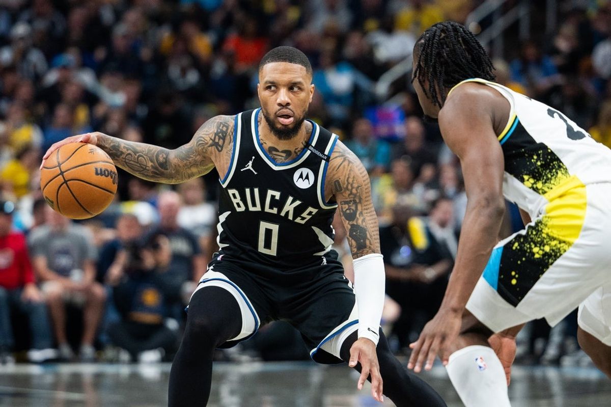 Apr 22, 2025; Indianapolis, Indiana, USA; Milwaukee Bucks guard Damian Lillard (0) dribbles the ball while Indiana Pacers forward Aaron Nesmith (23) defends during game two of first round for the 2024 NBA Playoffs at Gainbridge Fieldhouse. Mandatory Credit: Trevor Ruszkowski-Imagn Images