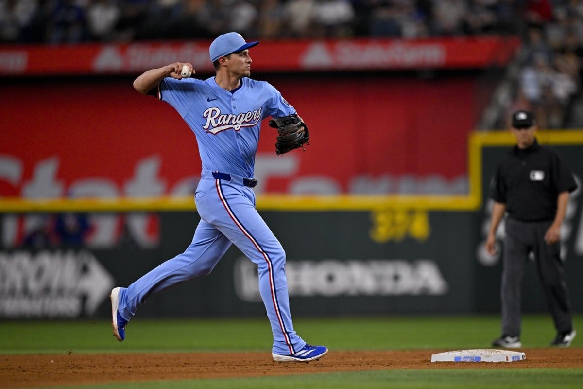 Apr 20, 2025; Arlington, Texas, USA; Texas Rangers shortstop Corey Seager (5) in action during the game between the Texas Rangers and the Los Angeles Dodgers at Globe Life Field. Mandatory Credit: Jerome Miron-Imagn Images