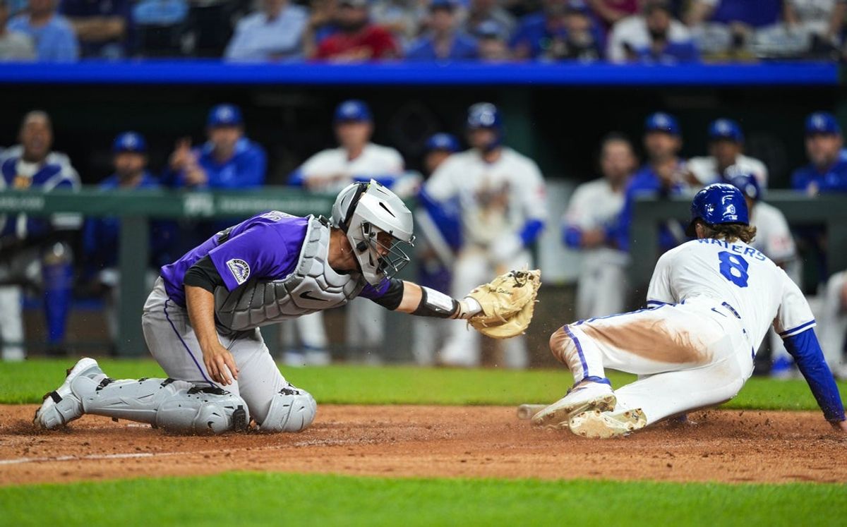 Apr 22, 2025; Kansas City, Missouri, USA; Kansas City Royals right fielder Drew Waters (8) scores a run against Colorado Rockies catcher Jacob Stallings (25) during the eighth inning at Kauffman Stadium. Mandatory Credit: Jay Biggerstaff-Imagn Images