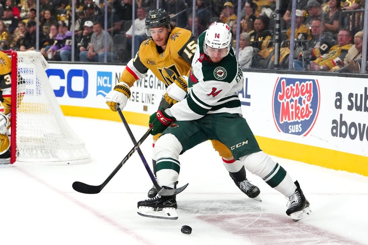 Apr 22, 2025; Las Vegas, Nevada, USA; Minnesota Wild center Joel Eriksson Ek (14) keeps the puck away from Vegas Golden Knights defenseman Noah Hanifin (15) during the first period of game two of the first round of the 2025 Stanley Cup Playoffs at T-Mobile Arena. Mandatory Credit: Stephen R. Sylvanie-Imagn Images