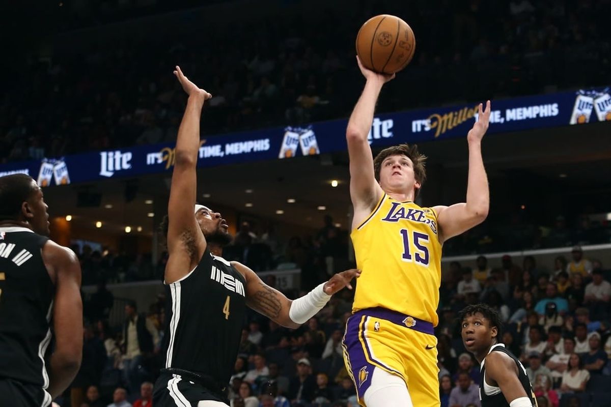 Apr 12, 2024; Memphis, Tennessee, USA; Los Angeles Lakers guard Austin Reaves (15) shoots as Memphis Grizzlies guard Jordan Goodwin (4) defends during the first half at FedExForum.