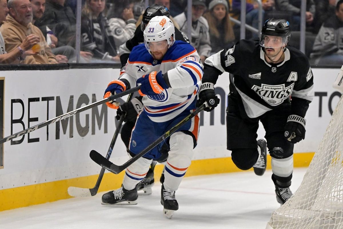 Apr 23, 2025; Los Angeles, California, USA; Edmonton Oilers left wing Viktor Arvidsson (33) and Los Angeles Kings center Phillip Danault (24) chase down the puck in the third period of game 2 of the 2025 Stanley Cup Playoffs at Crypto.com Arena. Mandatory Credit: Jayne Kamin-Oncea-Imagn Images
