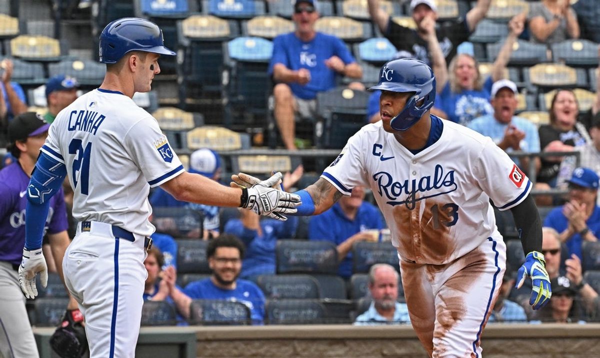 Apr 24, 2025; Kansas City, Missouri, USA;  Kansas City Royals designated hitter Salvador Perez (13) shakes hands with teammate Mark Canha (21) after scoring a run in the second inning against the Colorado Rockies at Kauffman Stadium. Mandatory Credit: Peter Aiken-Imagn Images
