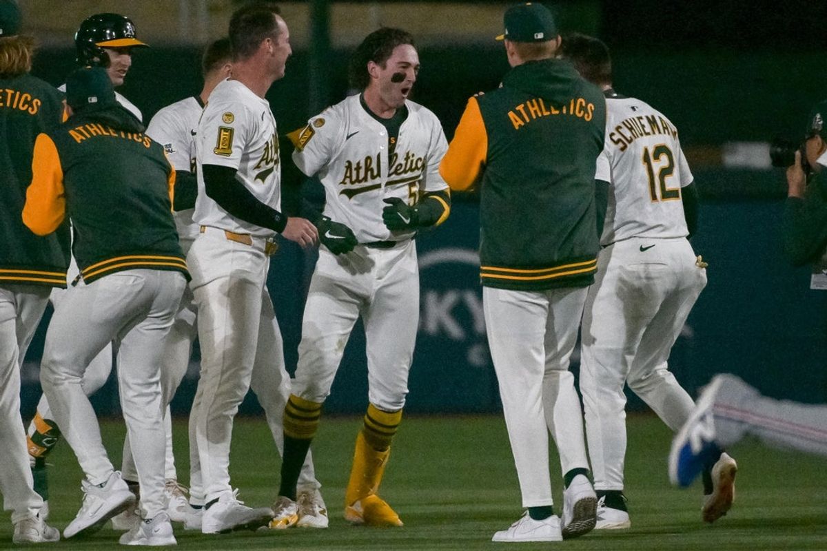 Apr 24, 2025; West Sacramento, California, USA; Athletics shortstop Jacob Wilson (5) celebrates with team mates after hitting an rbi single against the Texas Rangers during the ninth inning at Sutter Health Park. Mandatory Credit: Ed Szczepanski-Imagn Images